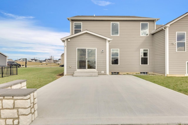 rear view of property featuring a lawn, fence, a patio, and entry steps
