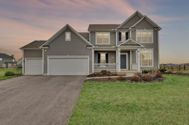 view of front of house featuring driveway, covered porch, a garage, and a yard