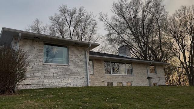 view of home's exterior with a yard and a chimney