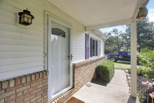 entrance to property featuring brick siding