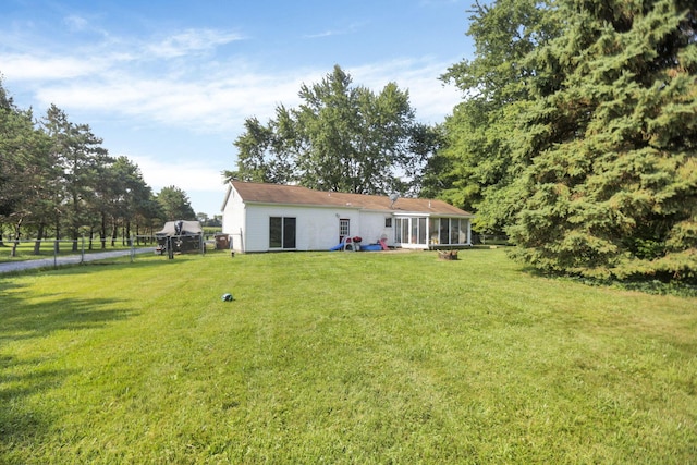 back of property featuring a lawn and a sunroom