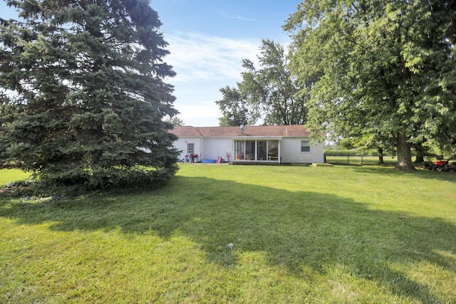 view of yard with fence and a sunroom