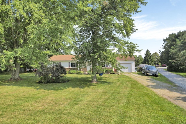 ranch-style home with a front lawn, an attached garage, and driveway