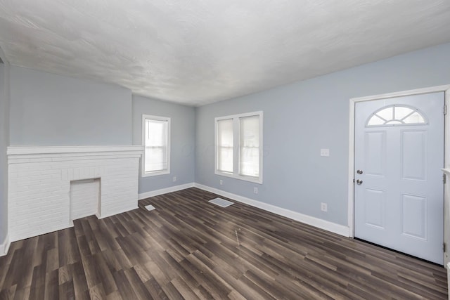 entrance foyer featuring dark wood-style floors, visible vents, and baseboards
