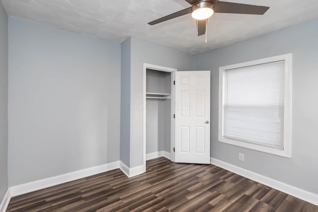 unfurnished bedroom with baseboards, a closet, a ceiling fan, and dark wood-style floors