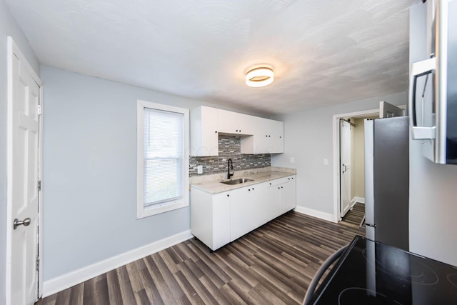 kitchen with a sink, tasteful backsplash, black electric range oven, dark wood finished floors, and white cabinets