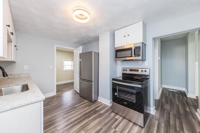 kitchen featuring dark wood-type flooring, white cabinets, a sink, and stainless steel appliances