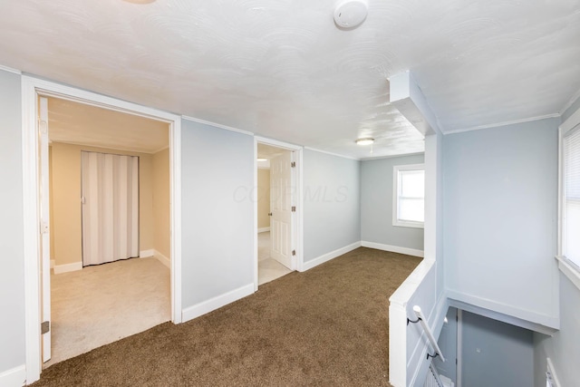 unfurnished room featuring carpet floors and baseboards