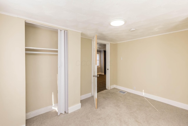unfurnished bedroom with baseboards, visible vents, crown molding, and light carpet