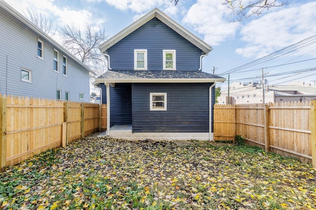rear view of property featuring a patio and a fenced backyard