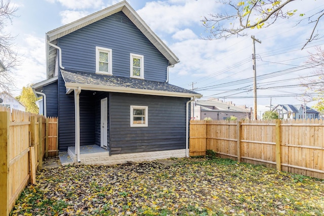 back of house with a fenced backyard