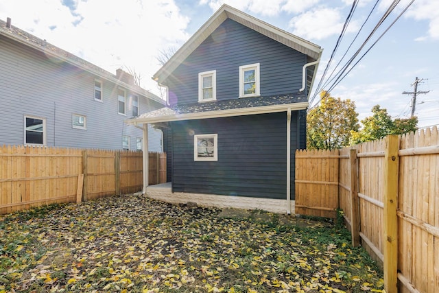 rear view of house featuring a fenced backyard