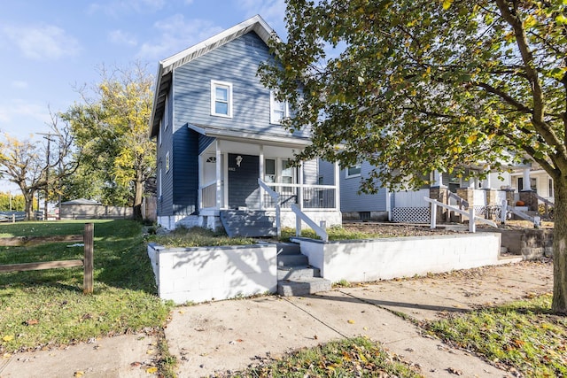 view of front of house featuring covered porch and a front lawn