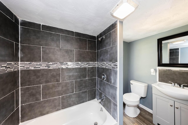 bathroom with shower / bathing tub combination, vanity, toilet, baseboards, and wood finished floors