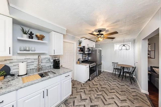 kitchen with a sink, open shelves, stainless steel appliances, white cabinets, and ceiling fan