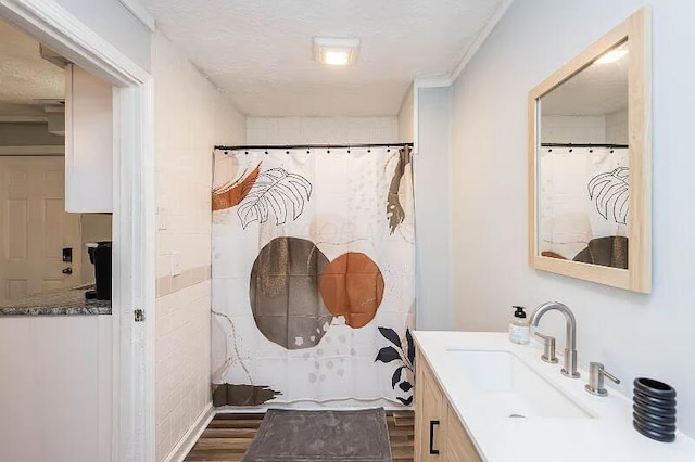bathroom featuring curtained shower, a textured ceiling, wood finished floors, and vanity