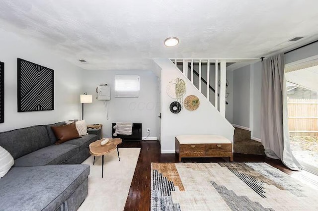 living area with baseboards, stairs, and wood finished floors