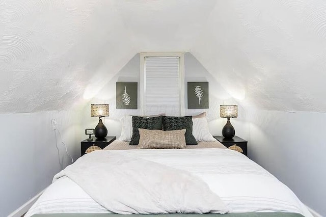 bedroom featuring lofted ceiling and a textured ceiling