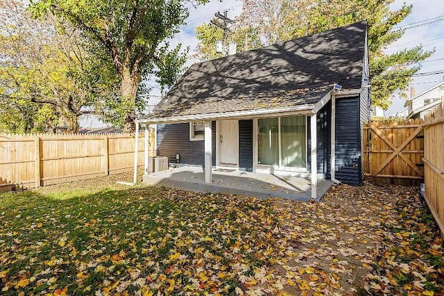 rear view of property featuring cooling unit, a fenced backyard, a patio, and roof with shingles