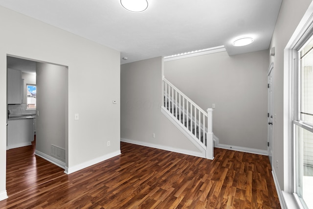 entryway with stairway, visible vents, baseboards, and wood finished floors