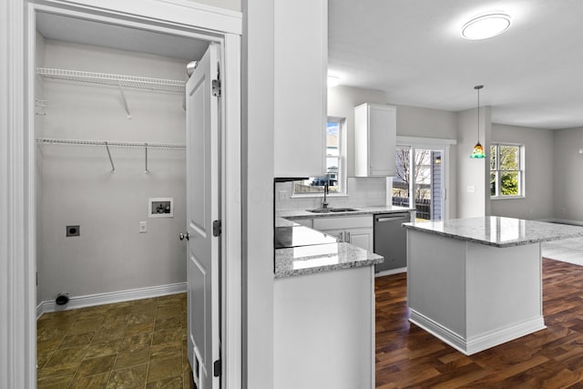 kitchen with a sink, a kitchen island, white cabinetry, decorative backsplash, and dishwasher