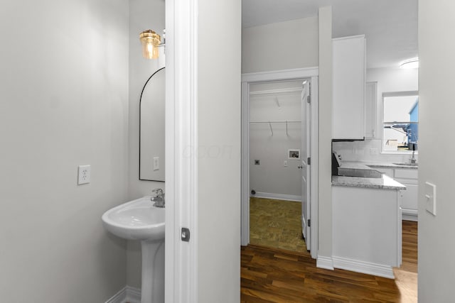 bathroom featuring wood finished floors, tasteful backsplash, and baseboards