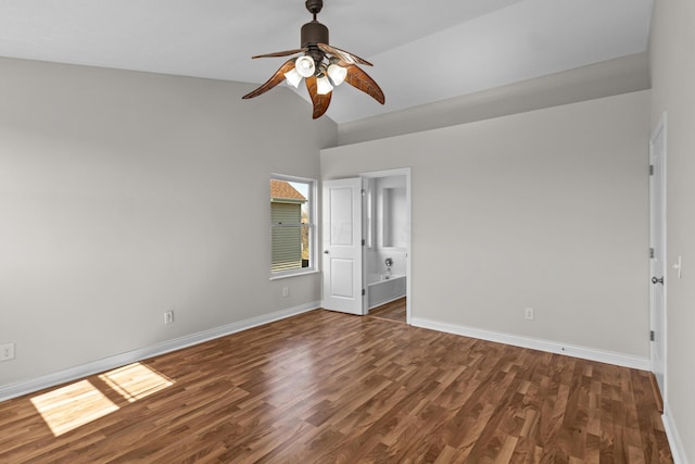 unfurnished bedroom featuring connected bathroom, ceiling fan, baseboards, vaulted ceiling, and wood finished floors