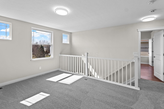 carpeted empty room with baseboards