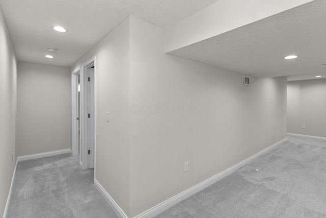 corridor featuring recessed lighting, baseboards, and light carpet