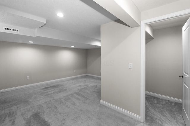 finished below grade area featuring visible vents, recessed lighting, baseboards, and carpet