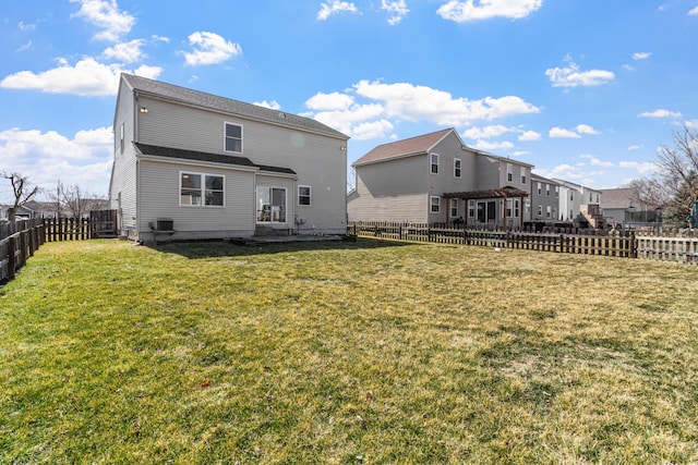 rear view of property with a lawn, central AC, and a fenced backyard