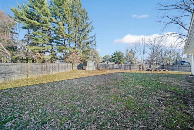 view of yard featuring an outbuilding, a fenced backyard, and a shed