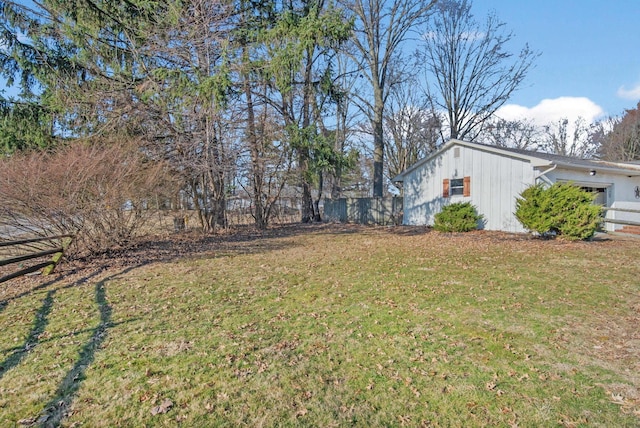 view of yard featuring a garage and fence