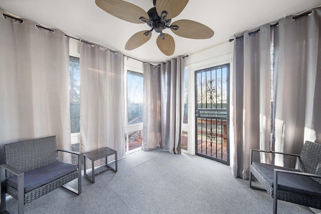 living area featuring carpet and ceiling fan