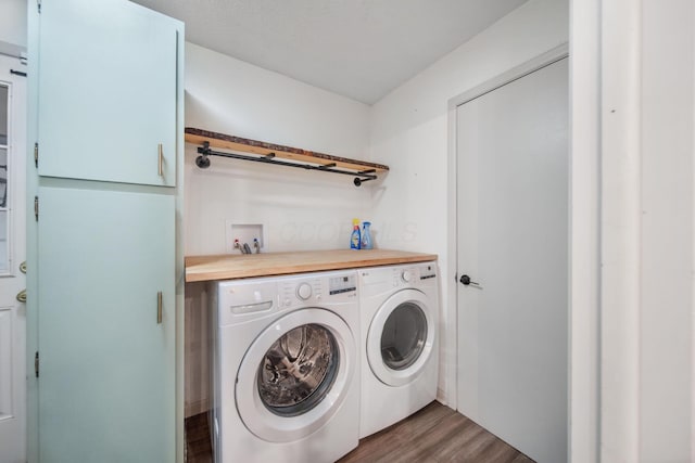 laundry room with dark wood finished floors, washing machine and dryer, and laundry area