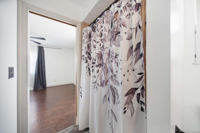 bathroom featuring baseboards, a shower with curtain, and wood finished floors