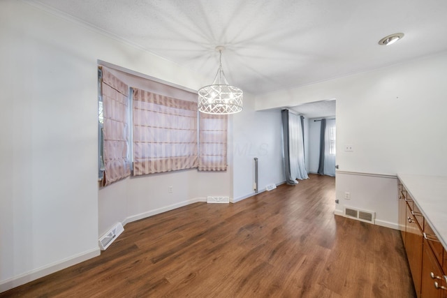 unfurnished dining area featuring visible vents, baseboards, and wood finished floors