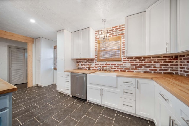 kitchen featuring wooden counters, a sink, a textured ceiling, stainless steel dishwasher, and a notable chandelier