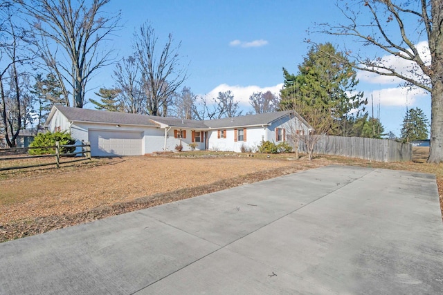 ranch-style home featuring an attached garage, fence, and driveway