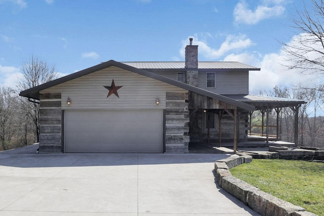 view of front of property featuring a chimney, driveway, metal roof, and a garage