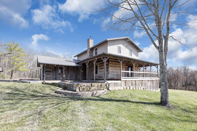 exterior space featuring a chimney, a front yard, and metal roof