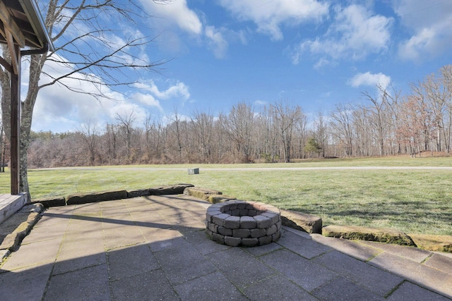 view of patio / terrace featuring a view of trees and an outdoor fire pit