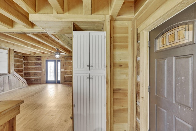 corridor with beamed ceiling, wood walls, and hardwood / wood-style flooring