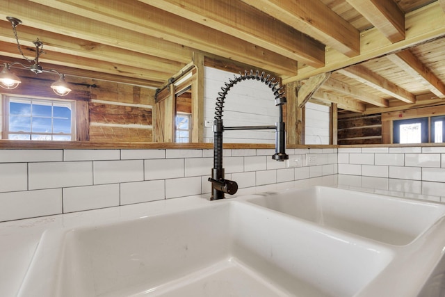 interior details featuring beamed ceiling and a sink