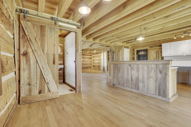 kitchen featuring white cabinets, pendant lighting, light countertops, and light wood-style floors