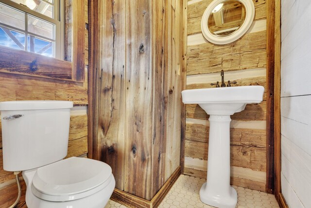 half bathroom with wooden walls and toilet