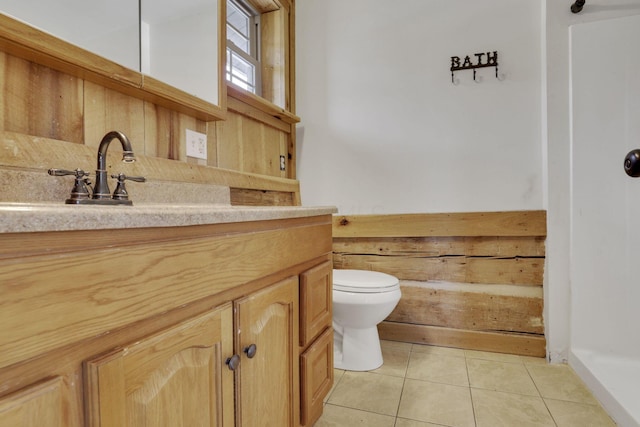 bathroom featuring tile patterned flooring, toilet, and vanity