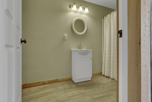 bathroom with vanity, baseboards, and wood finished floors