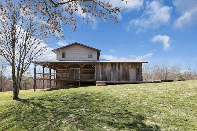 rear view of property with a yard and metal roof