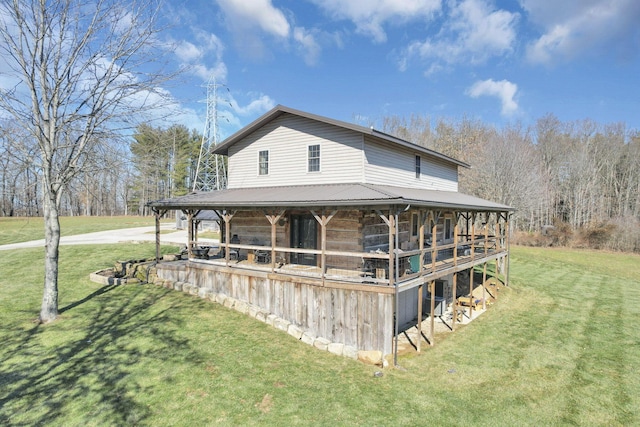 back of house with a lawn and metal roof